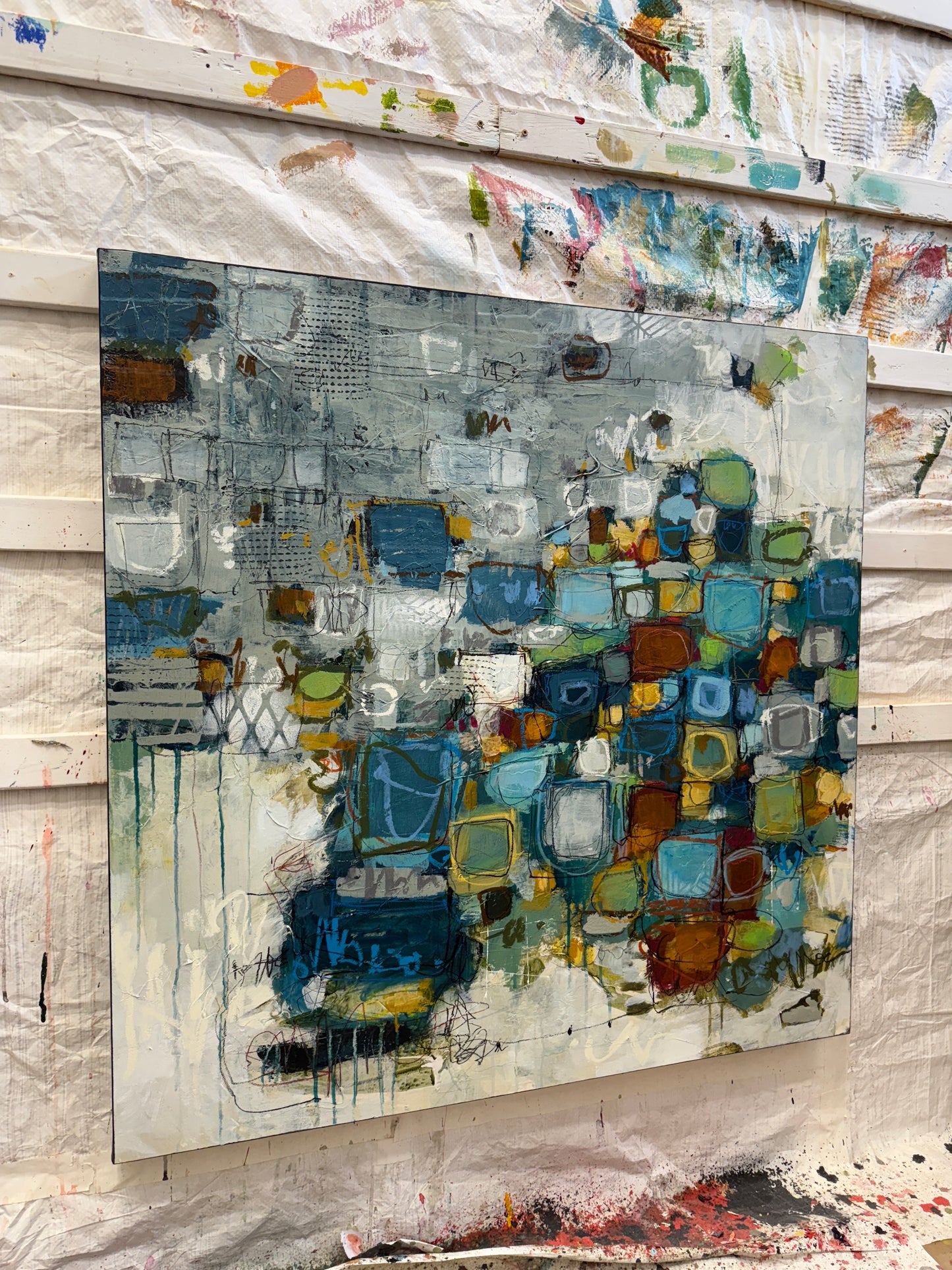 Abstract art piece with colorful square patterns on a textured surface