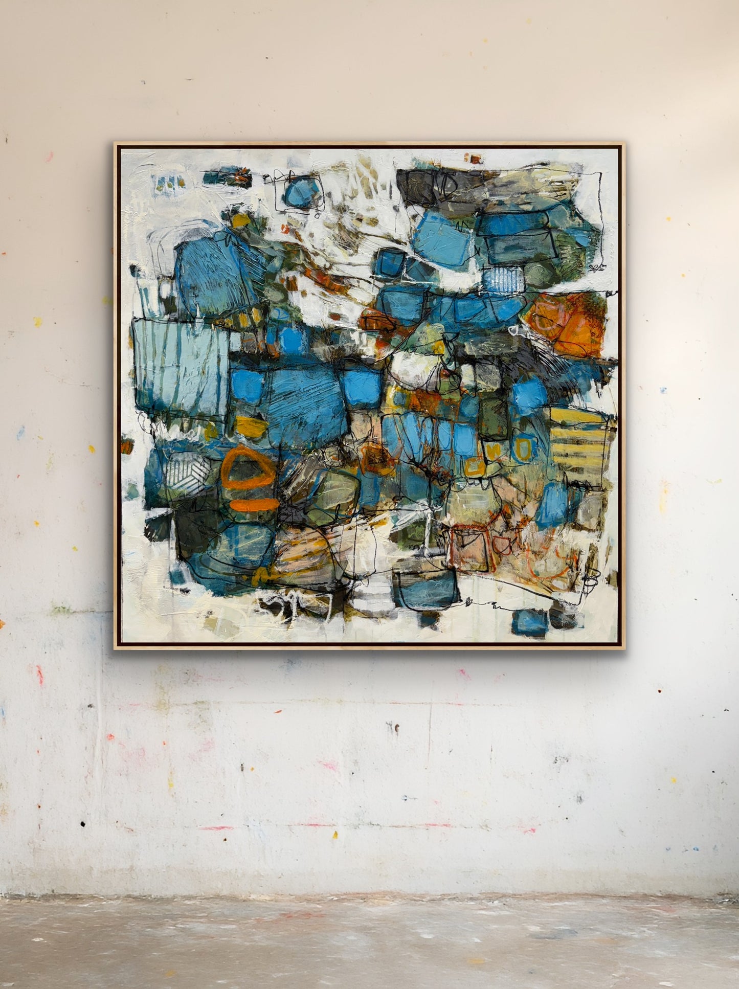 Abstract painting with blue and brown tones on a white wall