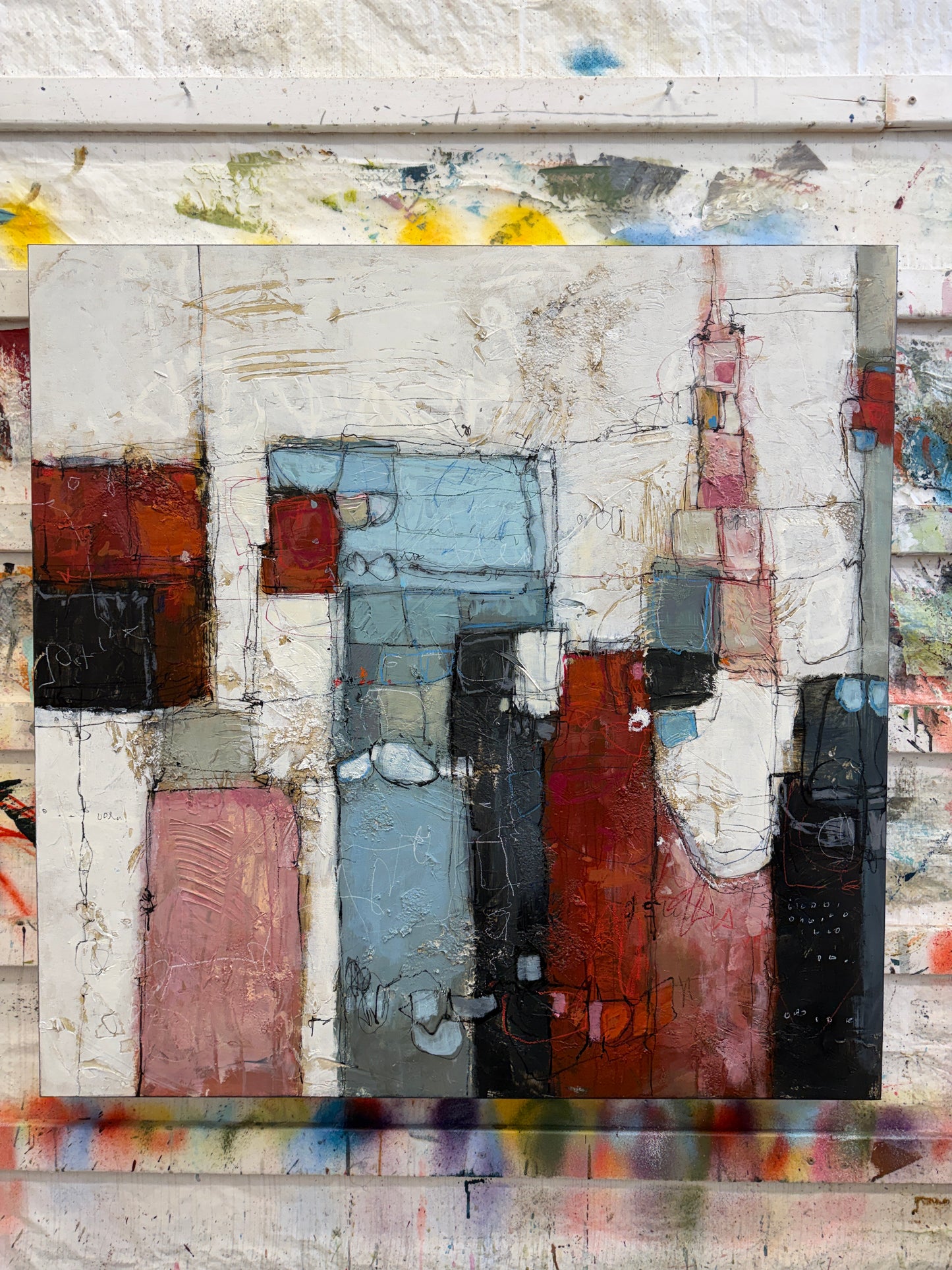 Abstract art piece with geometric shapes in various colors on a textured background