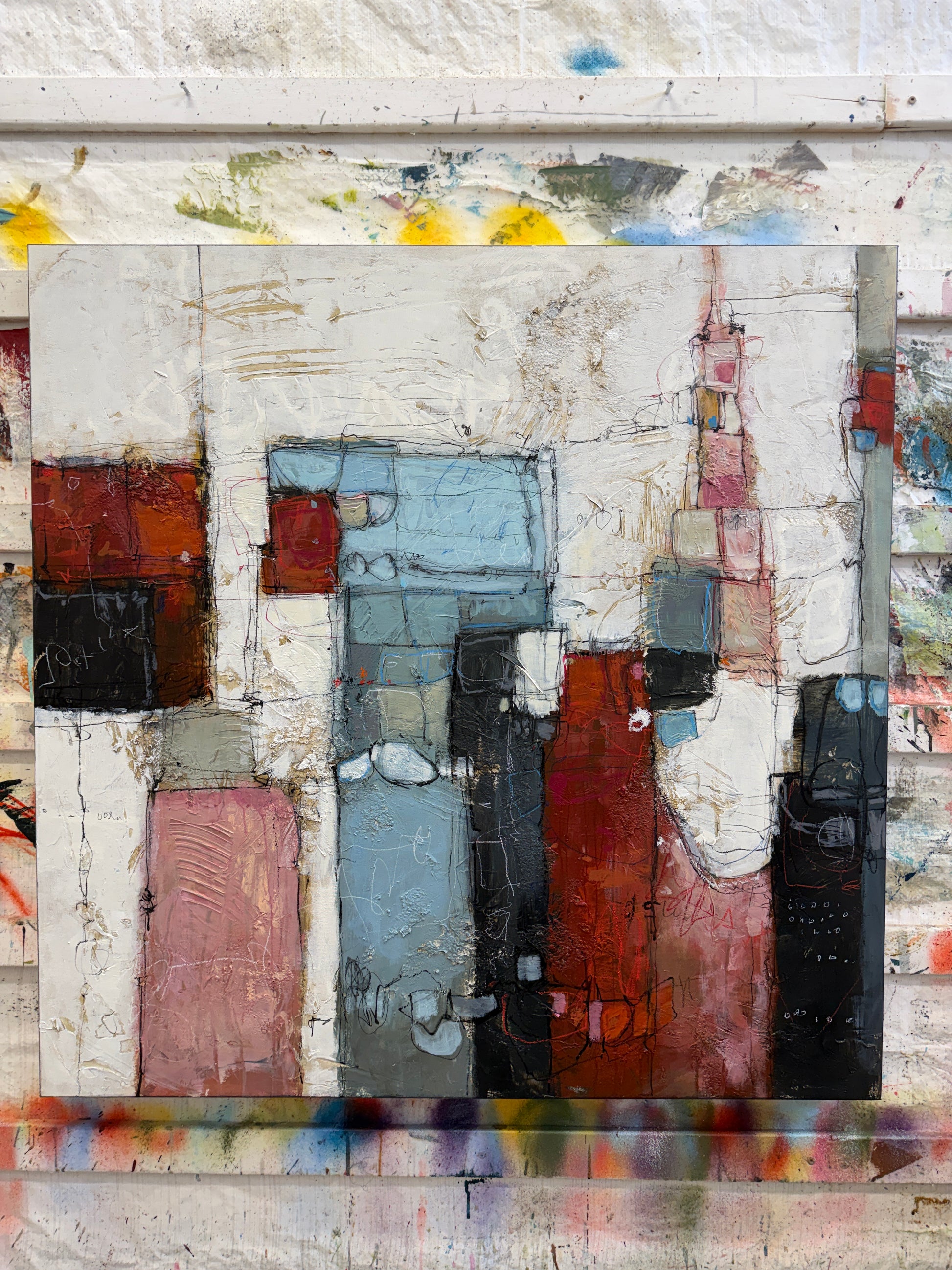 Abstract art piece with geometric shapes in various colors on a textured background