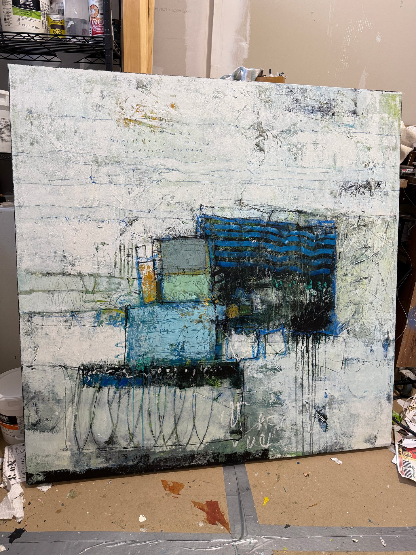 Abstract painting in a modern living room setting with a chair and decor items. paintings for sale lori mirabelli 48x48 inch
