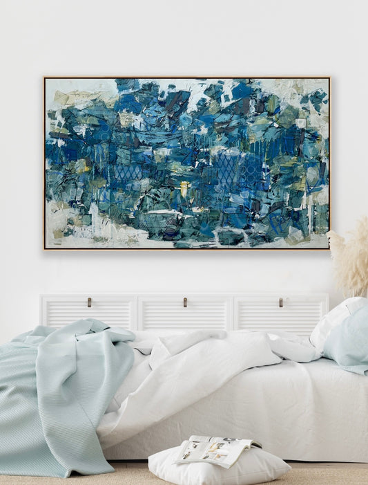 Large 48 x 72 inch abstract acrylic painting on canvas by Canadian artist Lori Mirabelli, featuring layered shades of deep and muted blue with hints of green, white, and texture, displayed above a cozy white bed with soft blue bedding in a modern minimalist bedroom. Contemporary fine art by Toronto-based abstract painter Lori Mirabelli, collected in homes across Canada and the U.S.