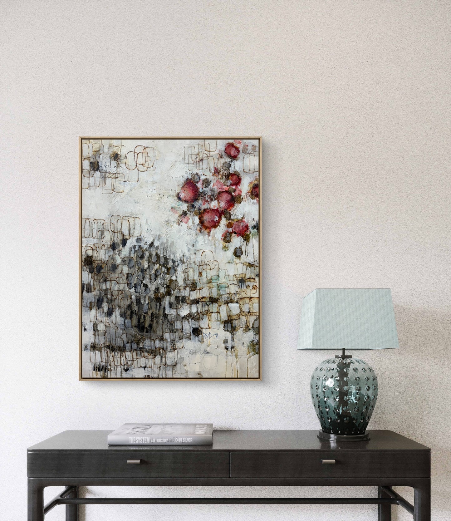 Abstract floral painting on a wall above a dark wooden console table with a lamp.