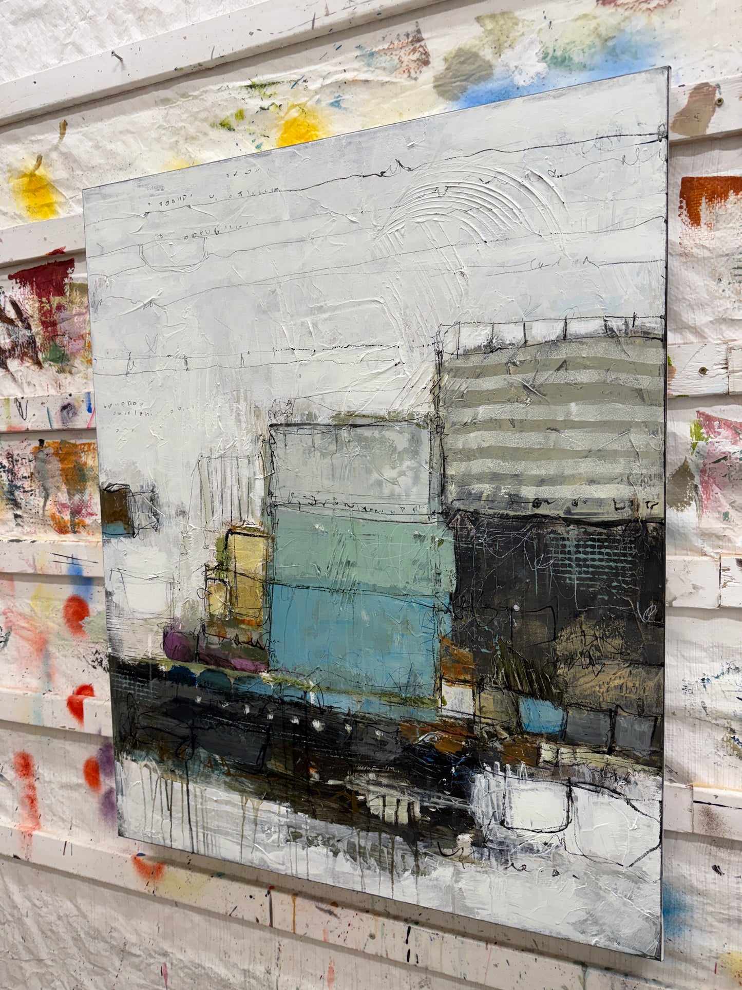 Abstract art piece with various colors and textures on a textured surface