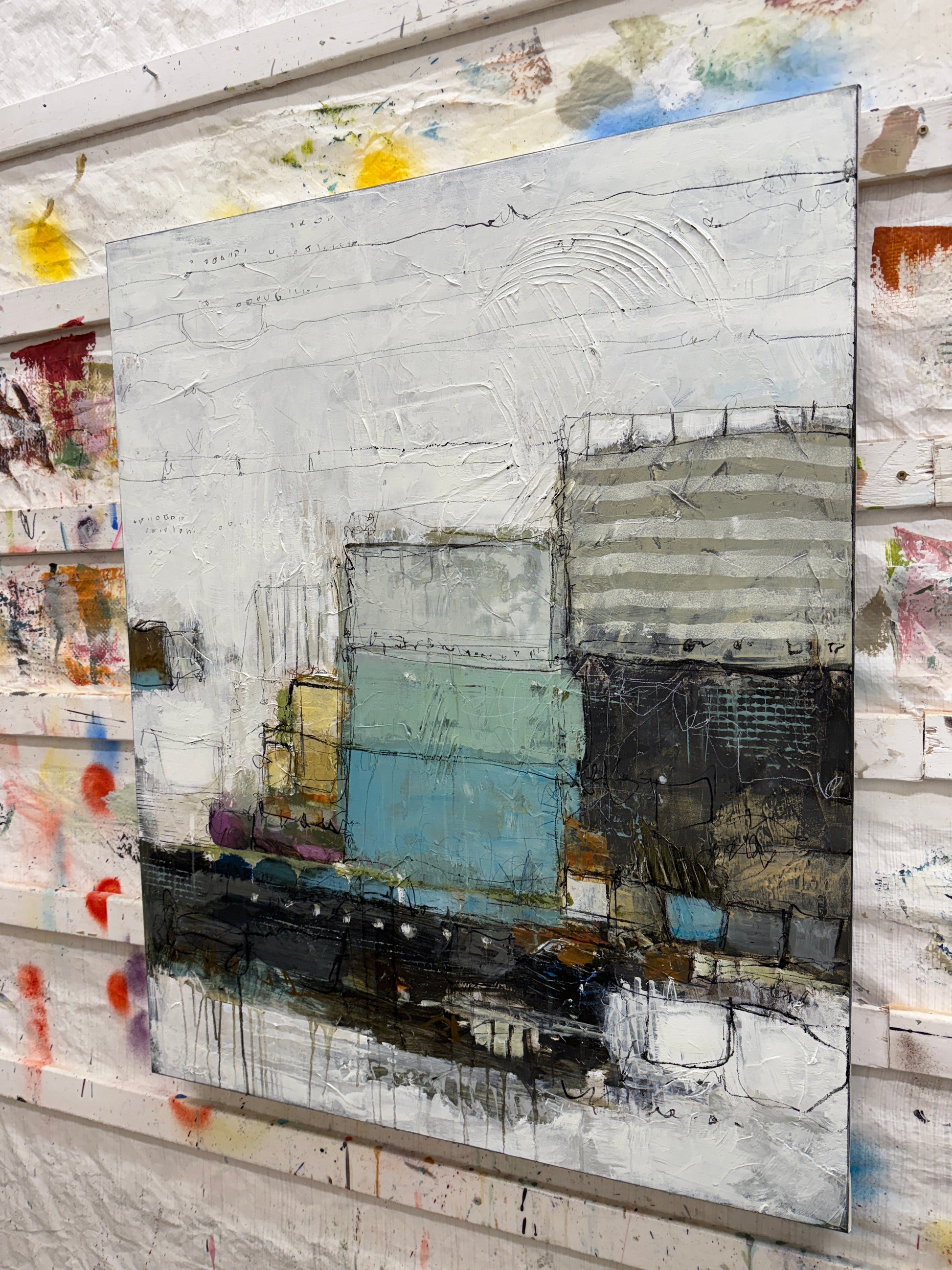 Abstract art piece with various colors and textures on a textured surface