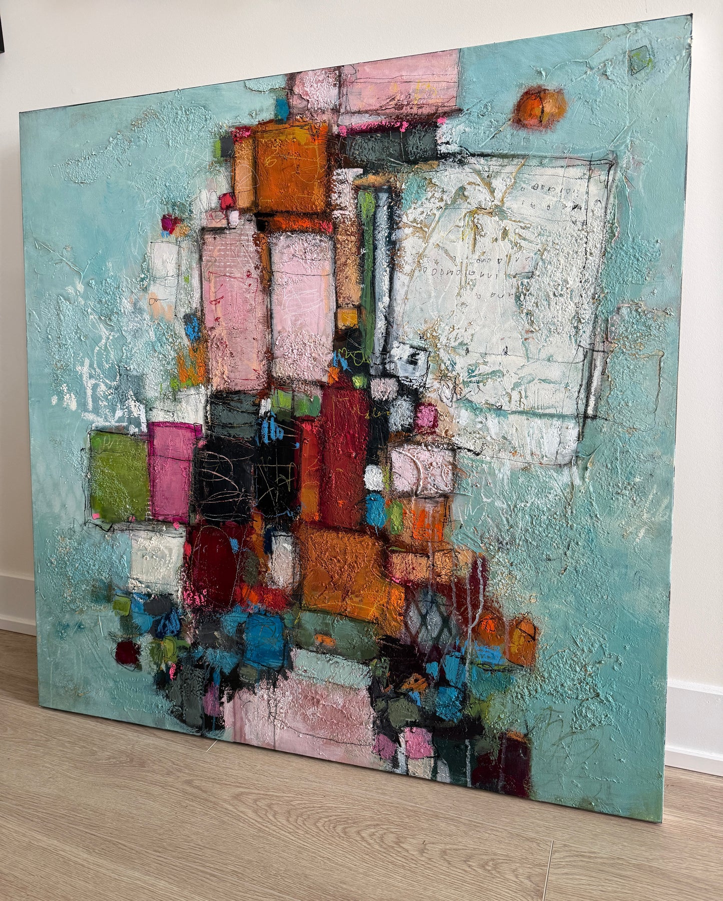 Abstract art piece with colorful geometric shapes on a textured surface.