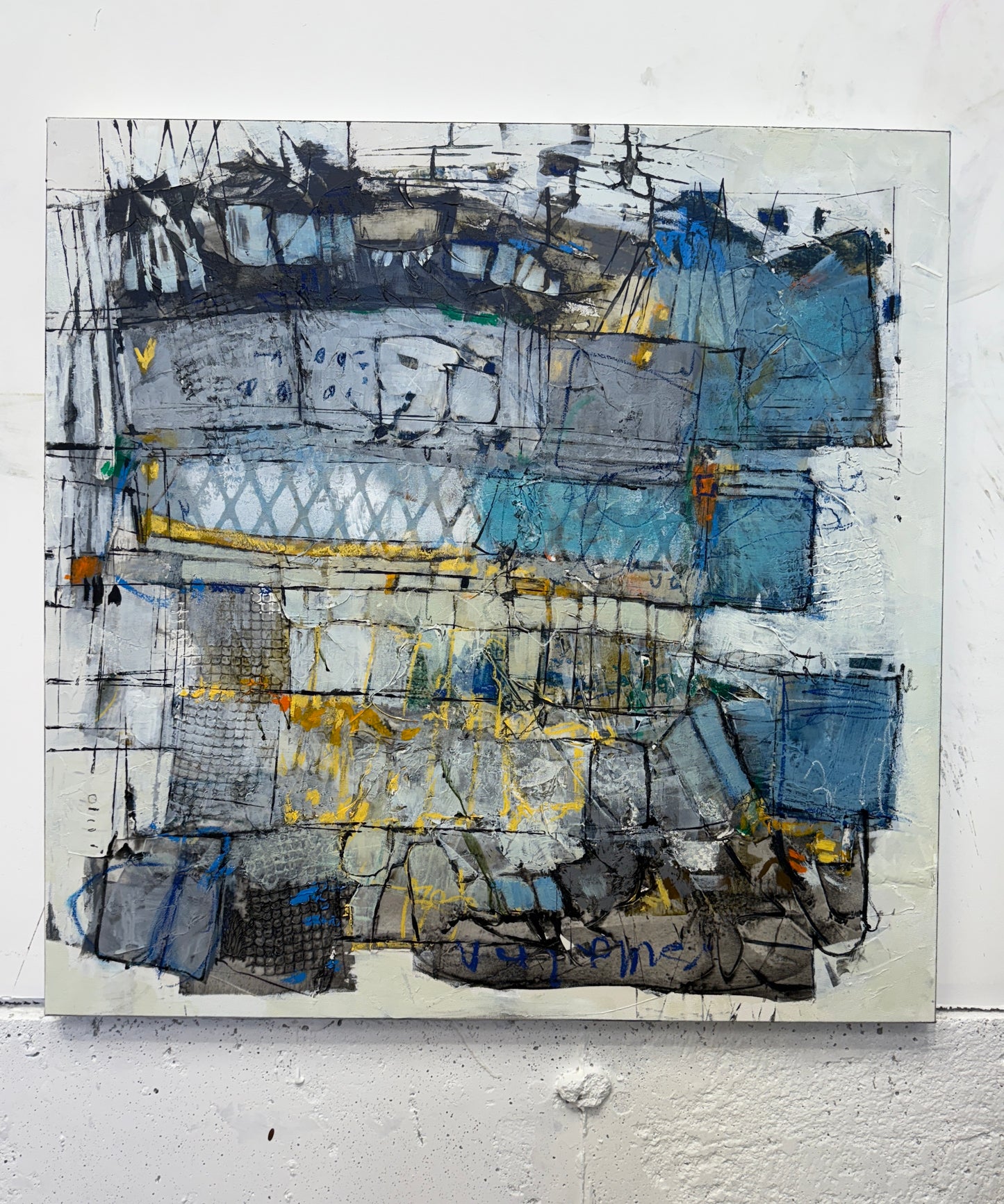 30x30 inch abstract acrylic painting on canvas featuring layered geometric shapes in grey, blue, and white with pops of bright yellow. The surface has rich texture, visible brushstrokes, and mark-making that gives it an urban, architectural feel with hints of movement and depth lori mirabelli