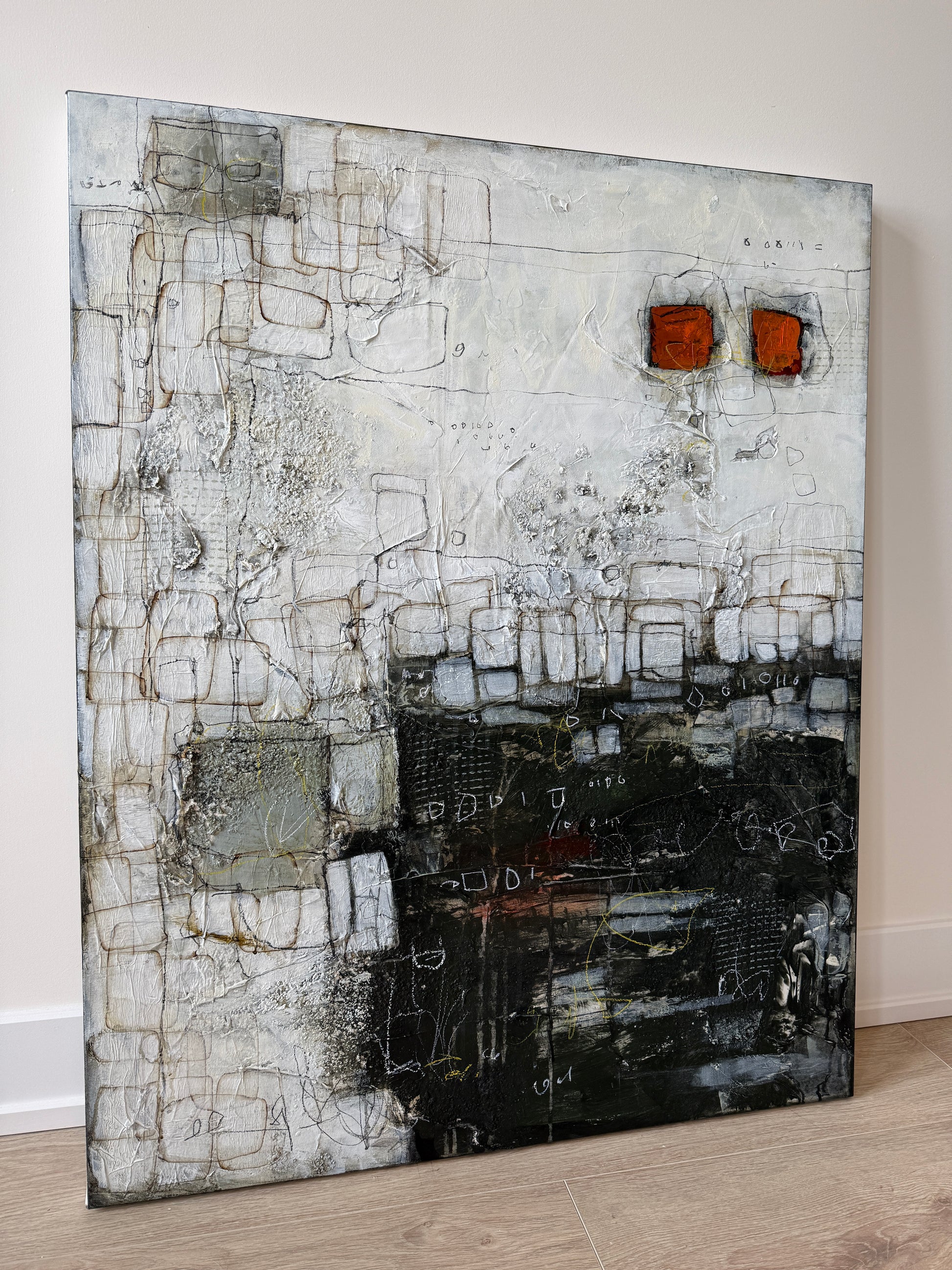 Abstract art piece with geometric patterns on a white wall.