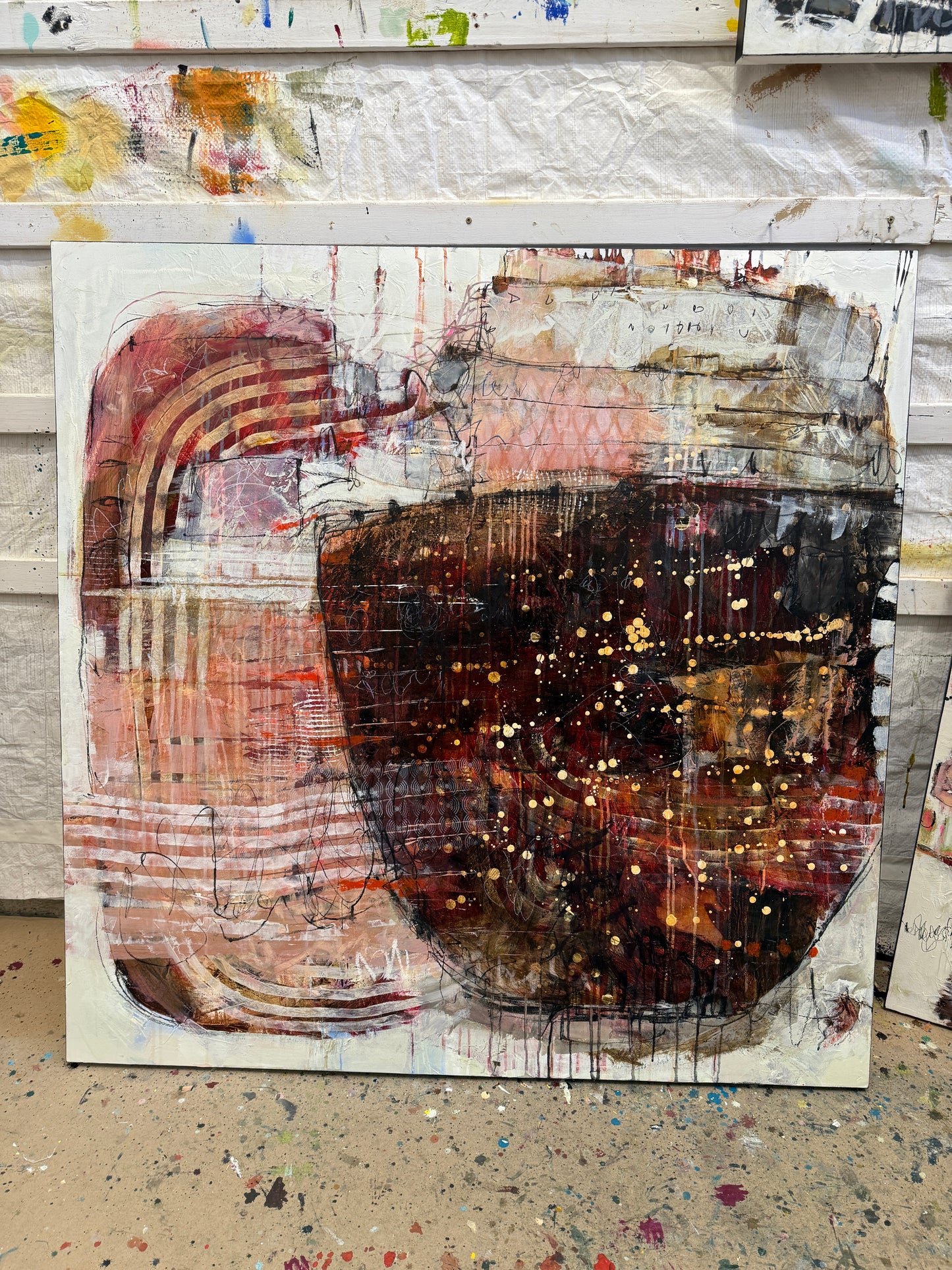 Abstract art piece with a central dark circular shape and layered textures. Lori Mirabelli Toronto 48x48