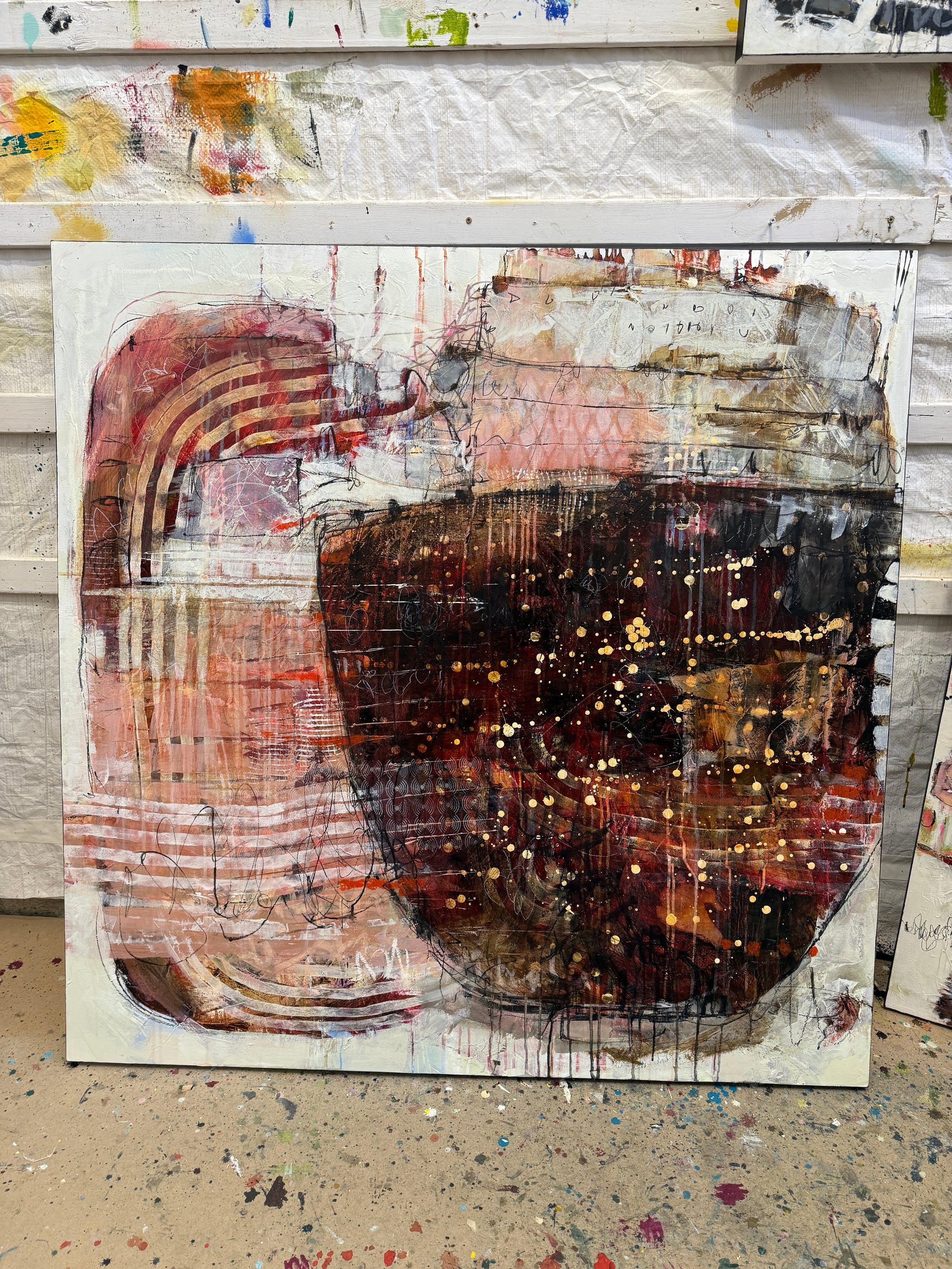 Abstract art piece with a central dark circular shape and layered textures. Lori Mirabelli Toronto 48x48