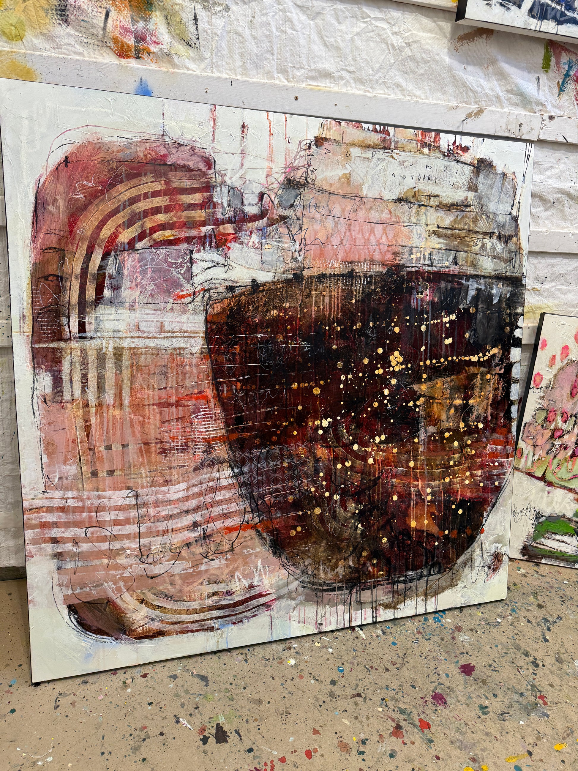 Abstract art piece with a central dark circular shape and layered textures. Lori Mirabelli Toronto 48x48