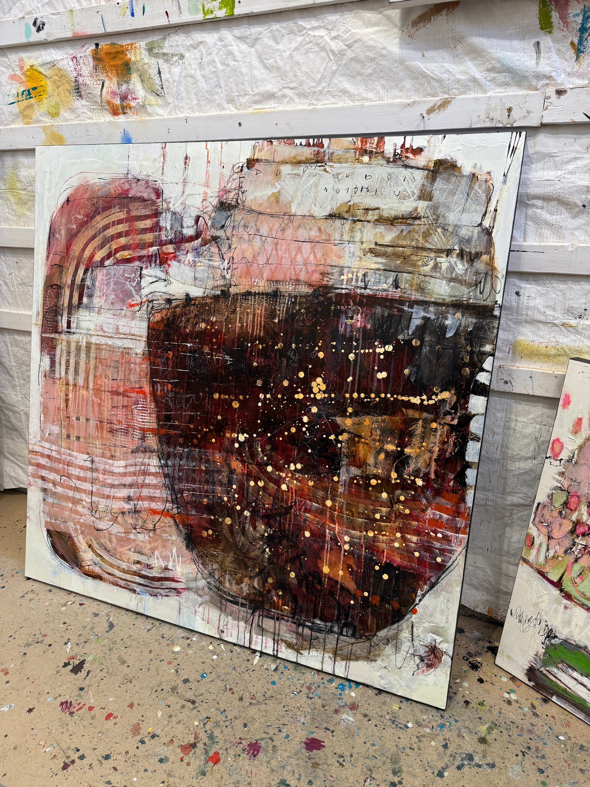 Abstract art piece with a central dark circular shape and layered textures. Lori Mirabelli Toronto 48x48