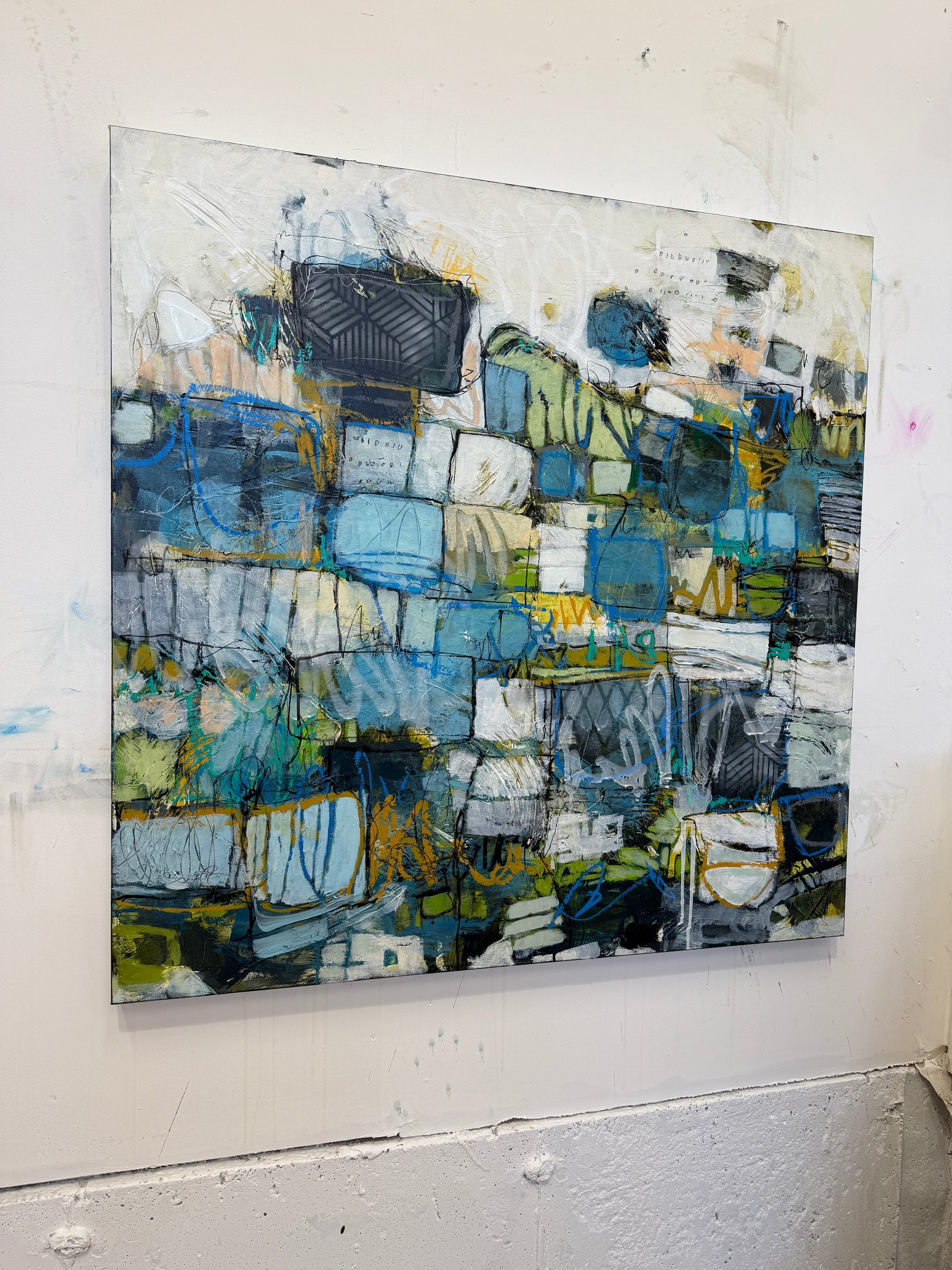 Abstract art piece with blue and green tones on a white surface
