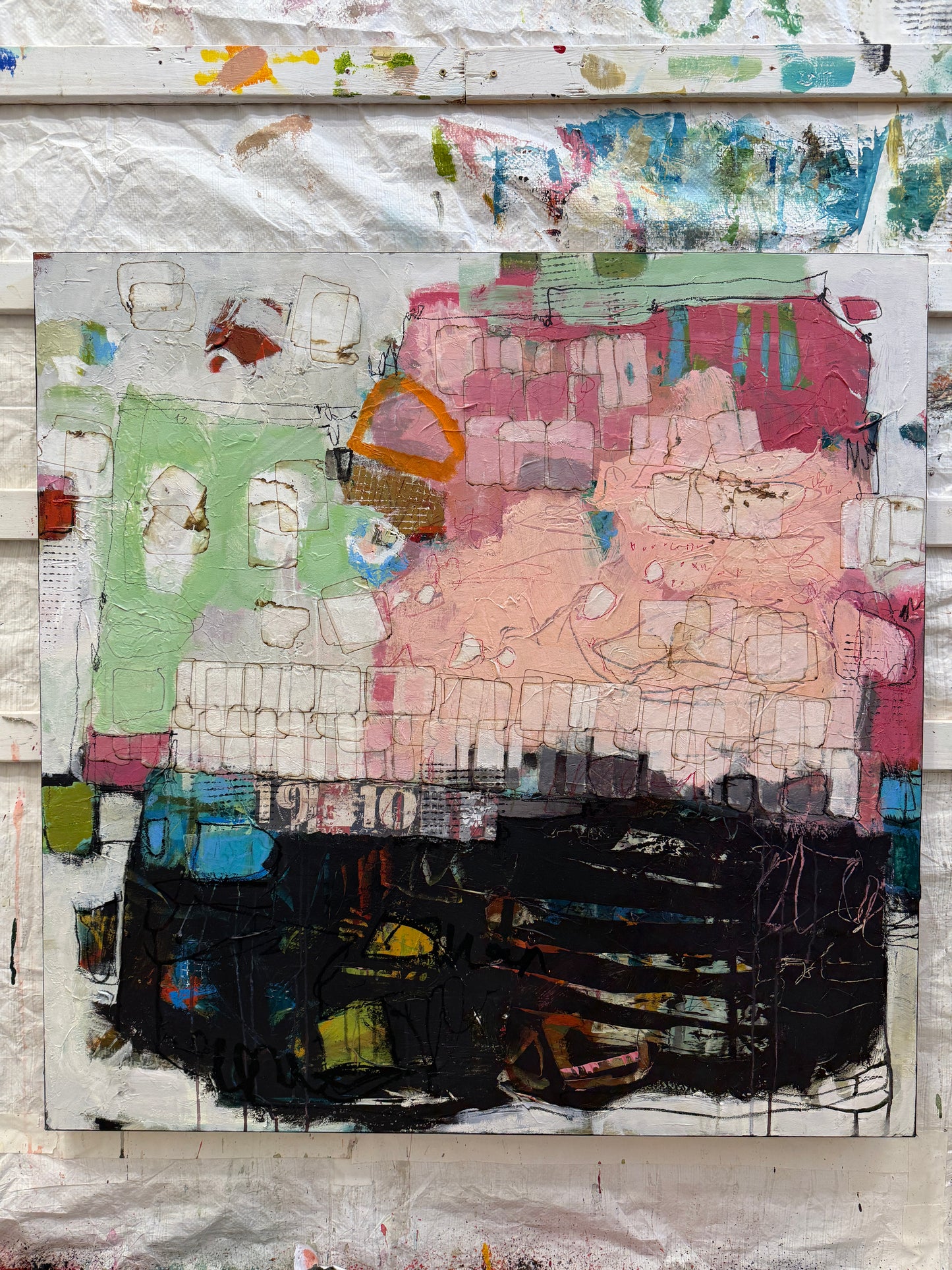 Abstract art piece with a mix of colors and textures on a textured surface.