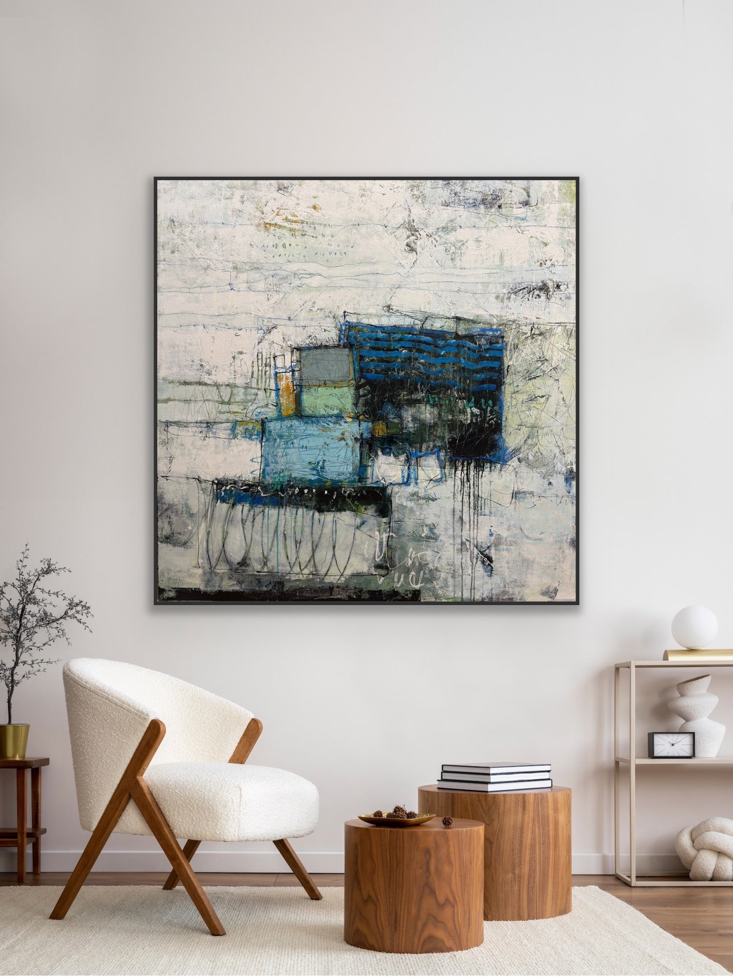 Abstract painting in a modern living room setting with a chair and decor items. paintings for sale lori mirabelli 48x48 inch