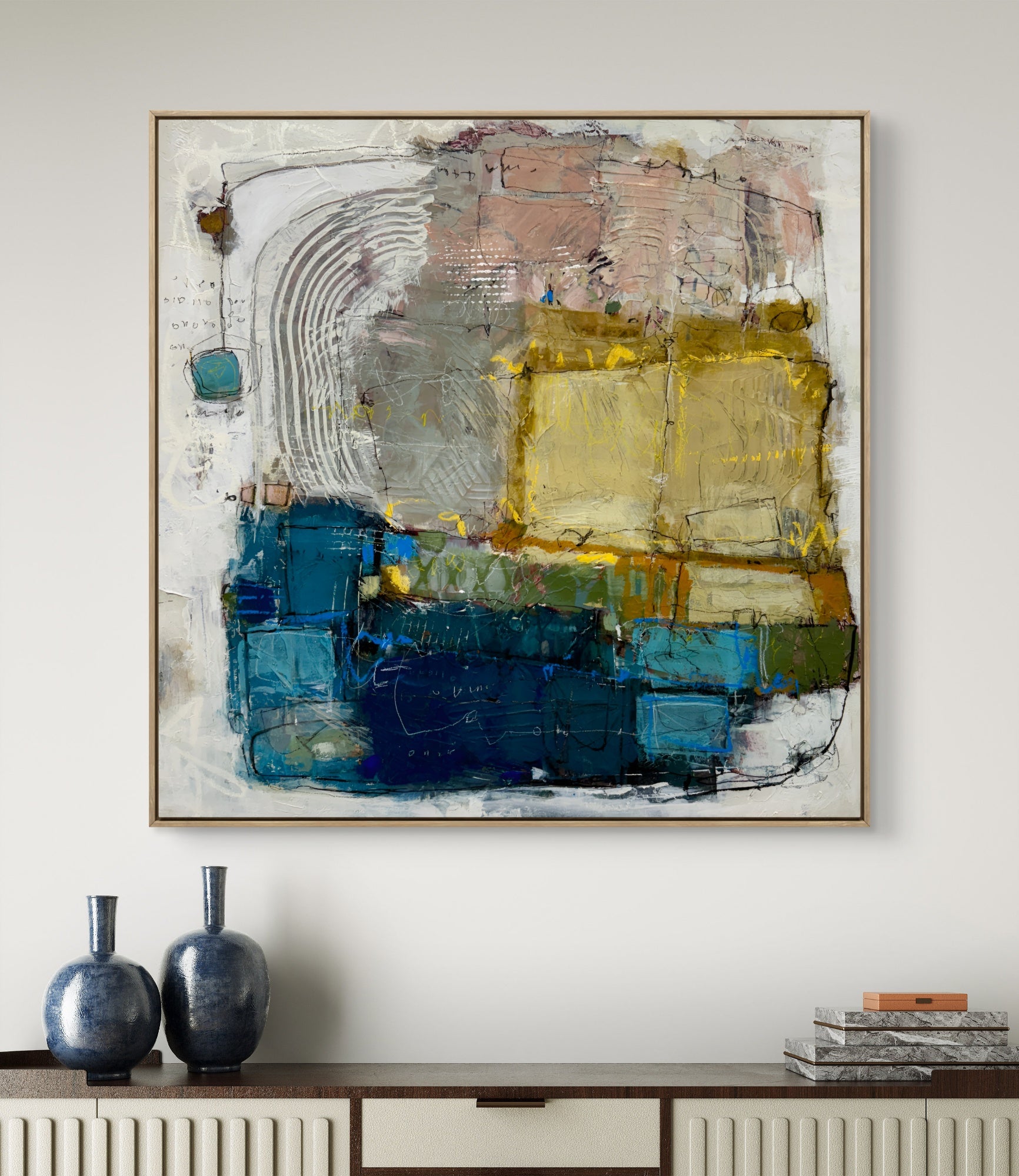Abstract painting with blue and yellow tones on a white wall above a console table.