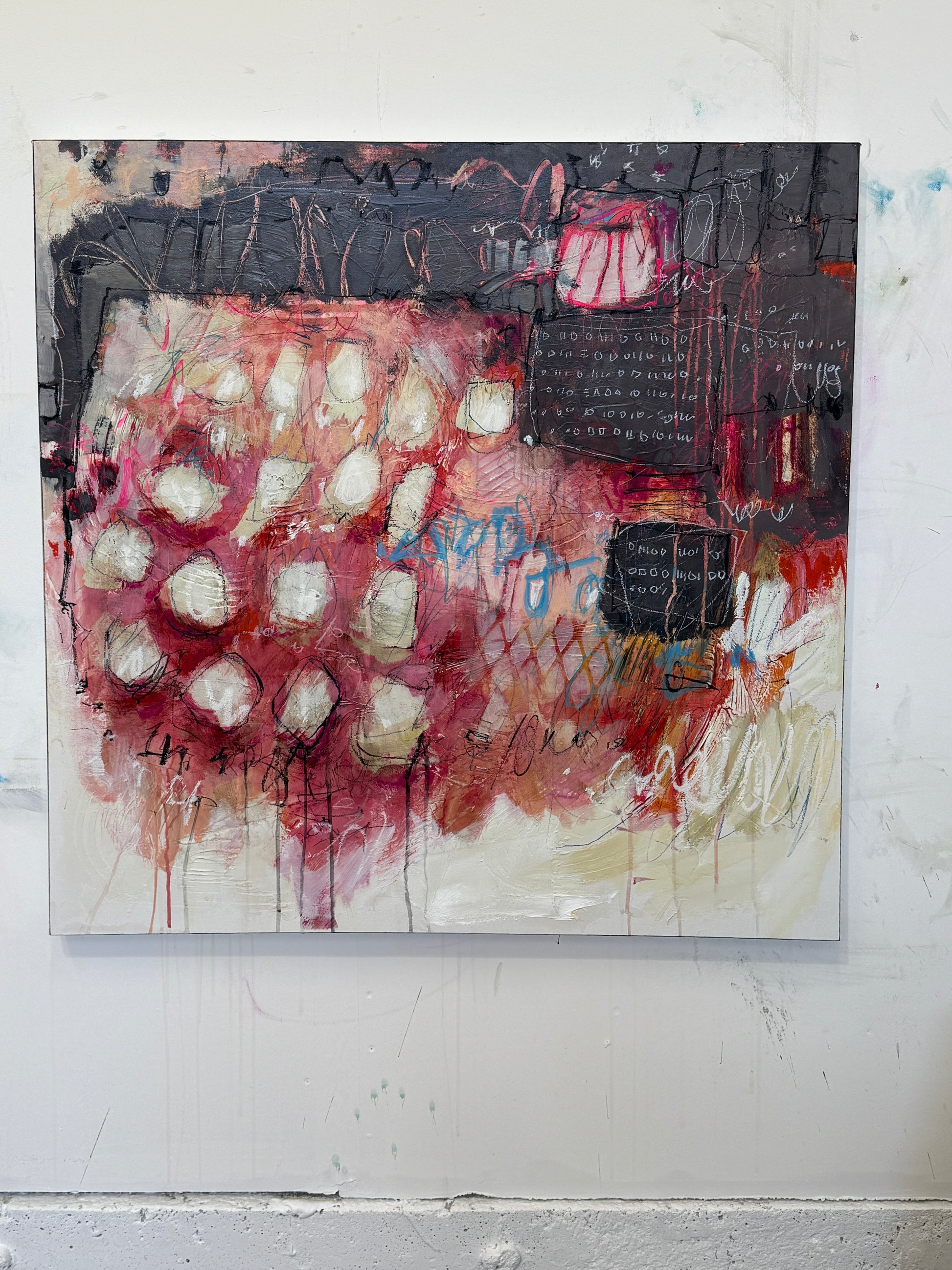 Abstract art piece with red, white, and black colors on a white wall.