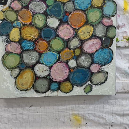 Contemporary abstract acrylic painting on canvas featuring layered colourful circular forms in soft blue, pink, green, gold, and neutral tones, surrounded by textured white space with expressive mark making and organic composition.