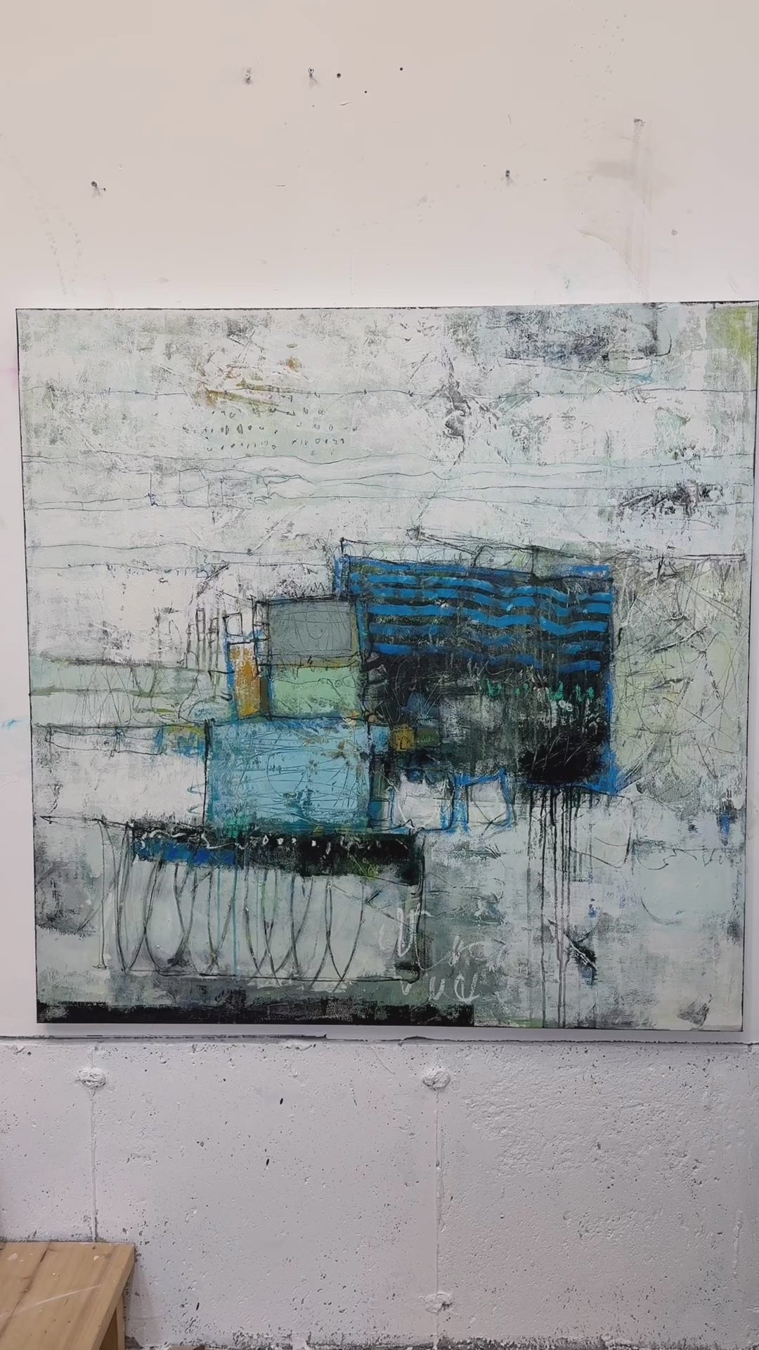 Abstract painting in a modern living room setting with a chair and decor items. paintings for sale lori mirabelli 48x48 inch