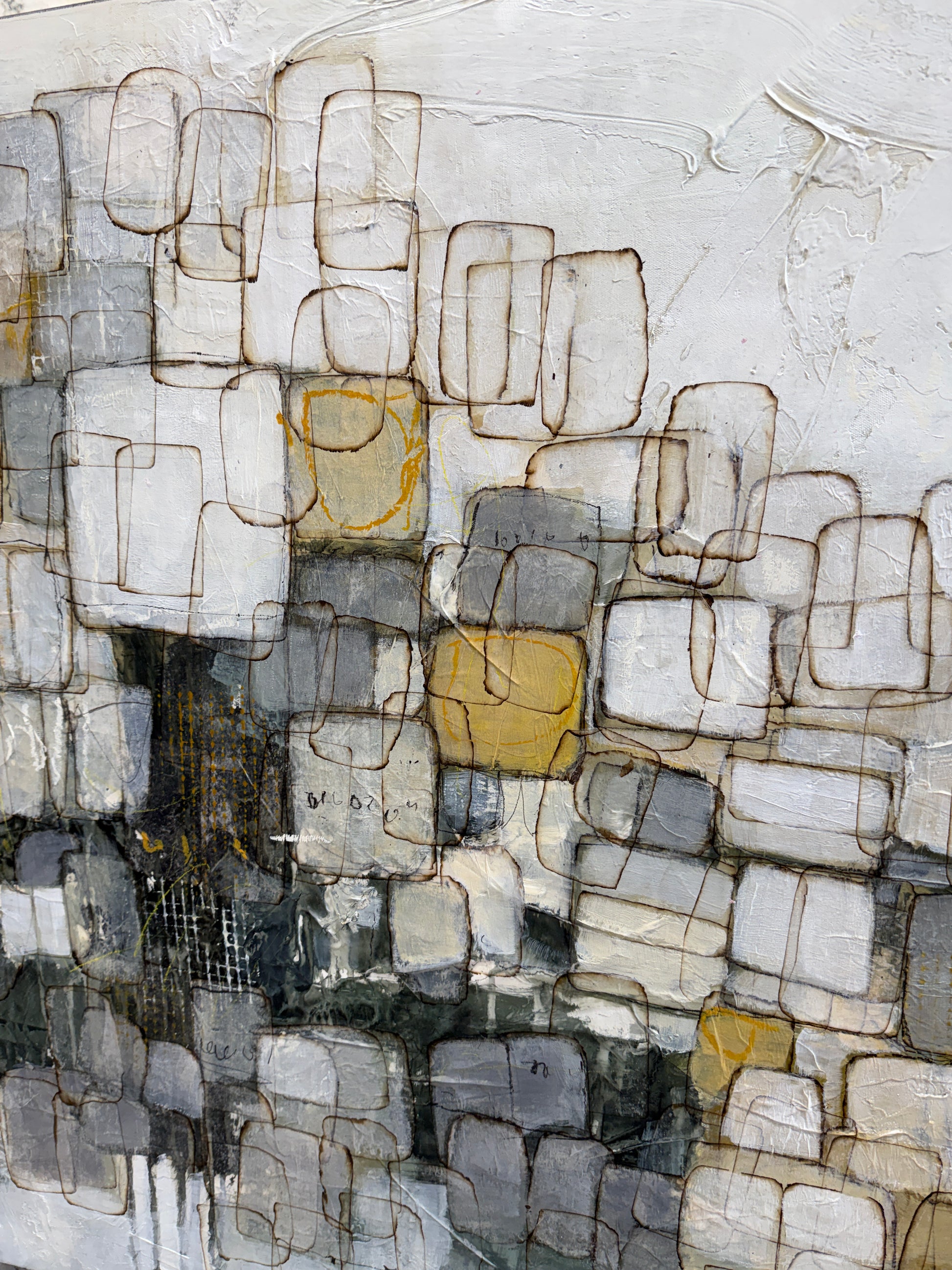 Abstract mixed-media painting featuring a grid-like pattern of overlapping rectangular blocks in shades of gray, white, black, and muted gold, outlined with fine brown lines.